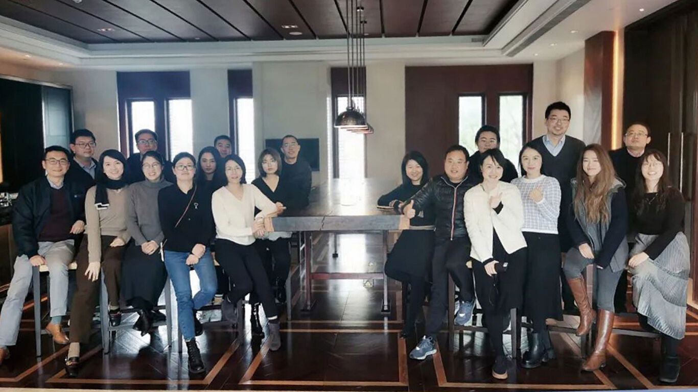 Watts China Sales team gathered around a meeting table posing.